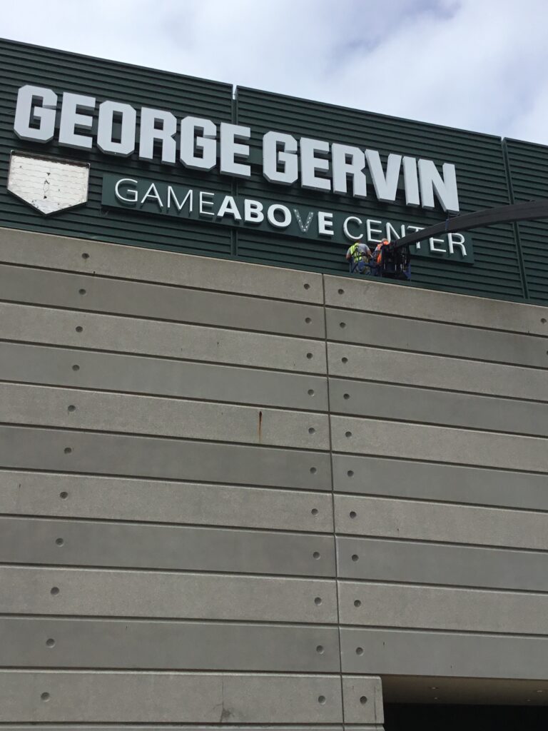 Crane installing new lettering on the building