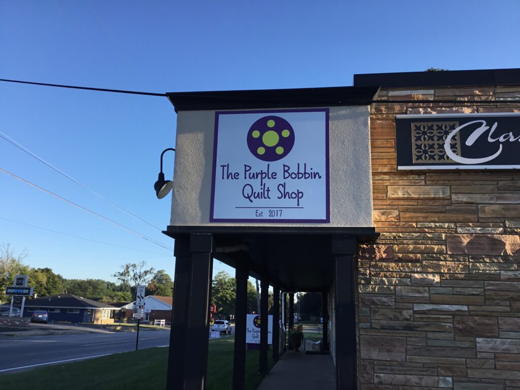 The Purple Bobbin Quilt Shop wall sign in Jackson, MI